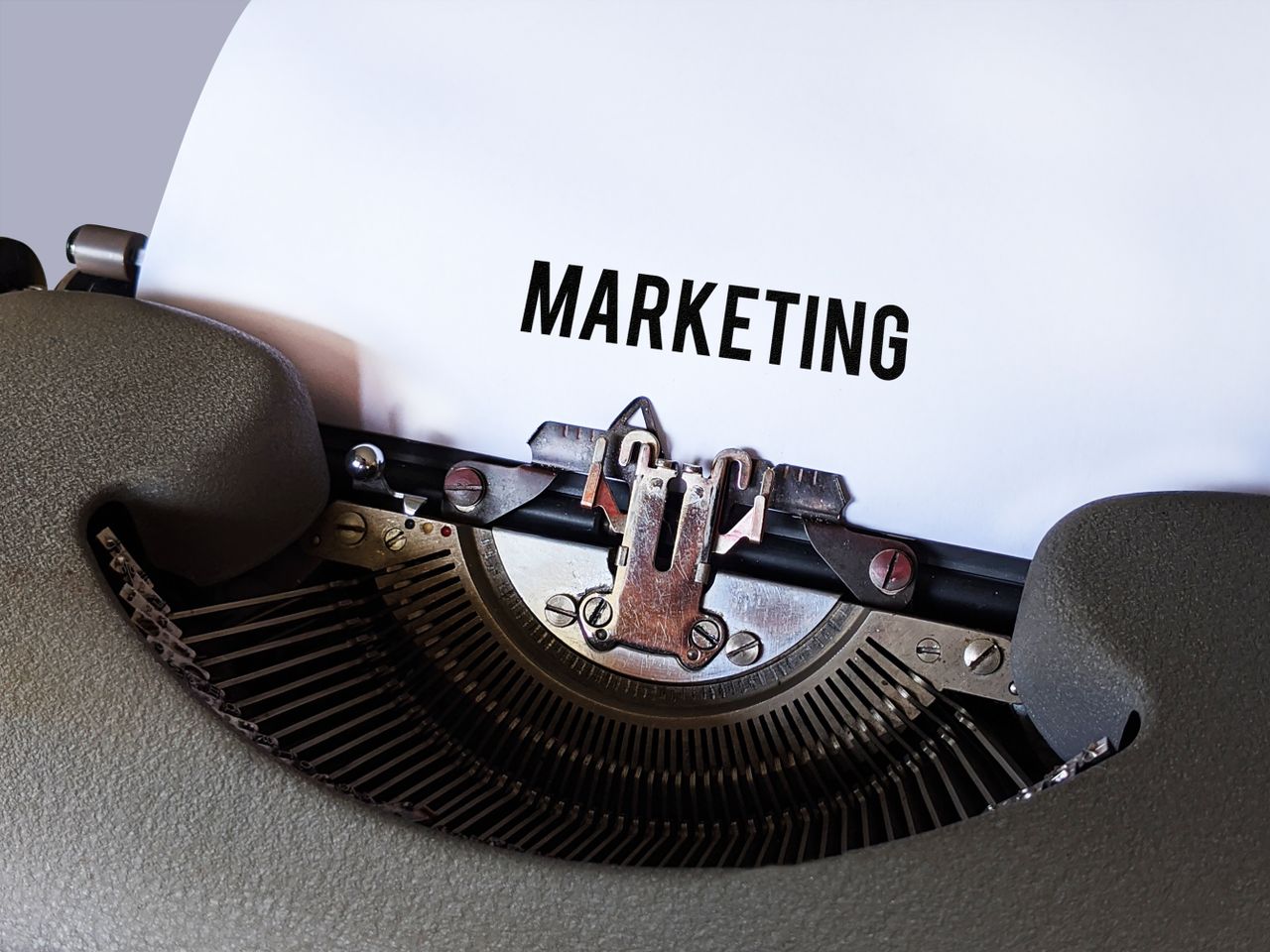 team-03 Close-up of a vintage typewriter with the word Marketing on paper, conveying a retro business theme.