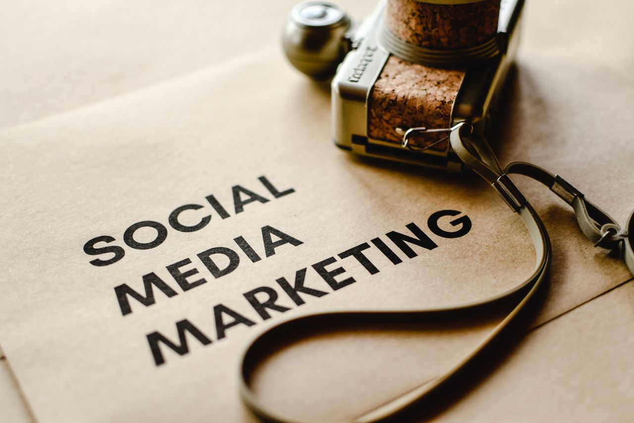 who-we-are Close-up of a camera placed on brown paper with Social Media Marketing text, emphasizing digital marketing themes.