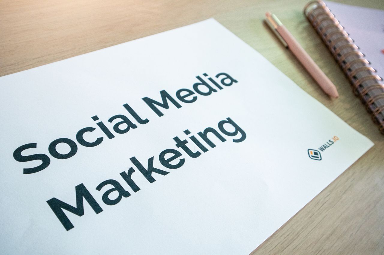 team-01 Close-up of a social media marketing document on a desk with a pen and notebook.
